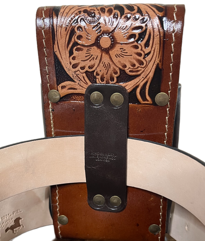 Close-up of a brown leather belt with intricate designs and metal buckles.